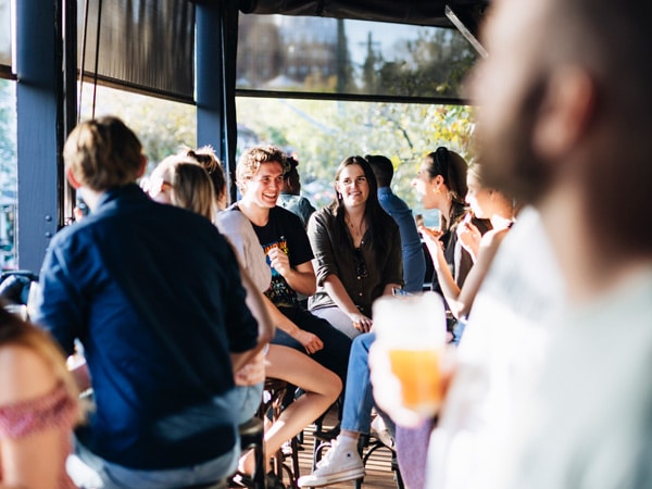 People in a room talking, drinking, and laughing.