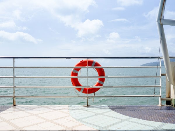 Onboard cruise ship with view of ocean, land and lifesaving ring