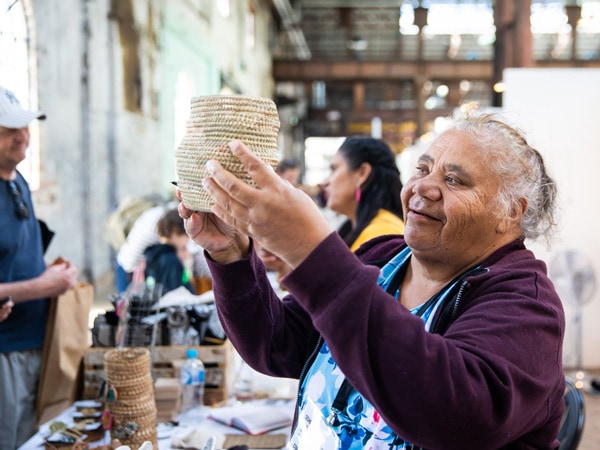 A woman holding a vase at a market.