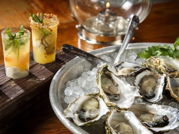 Oysters and drinks on a table.