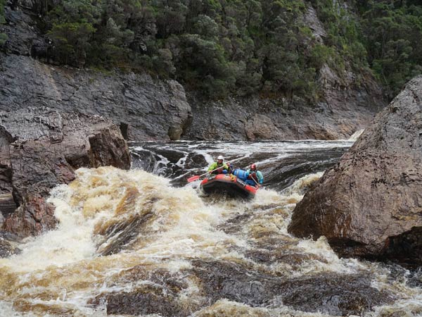 Two people in a raft navigating the rapids of the Great Ravine