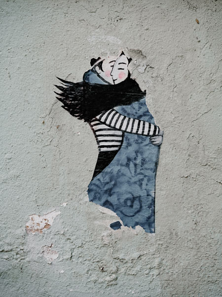 Two people painted on wall hugging
