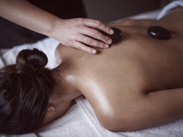 a woman getting a stone massage at Elysia Wellness Retreat