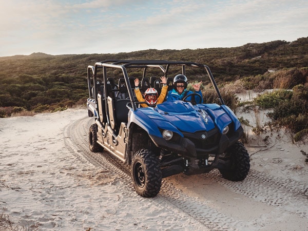 Family having fun on quad bike at Little Sahara Adventure Centre on Kangaroo Island. 