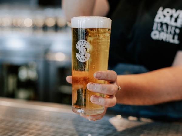 a bartender holding a cold beer at Sydney Brewery