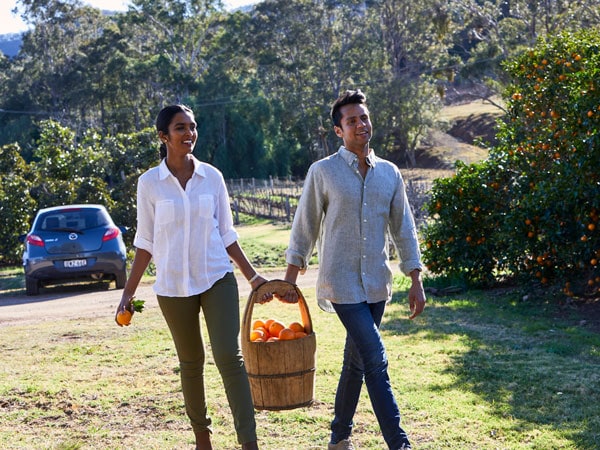 a couple holding a basket filled with fruits at Tinklers Wine, Pokolbin