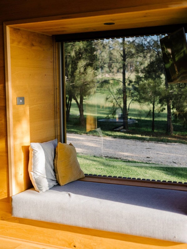 a bed facing the window at Handcrafted Cabin in the Vines