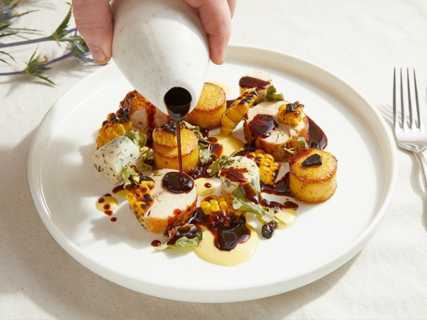 Sauce being poured onto a chicken dish from Restaurant Botanica