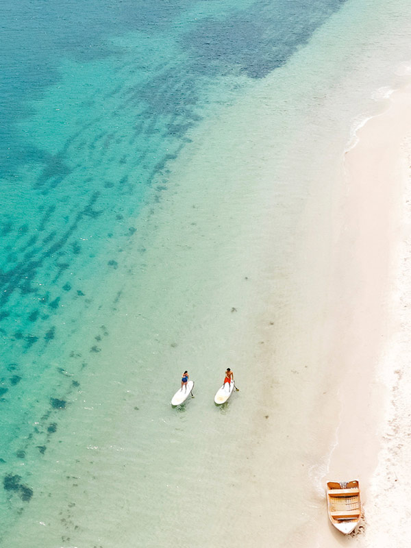 Couple stand-up paddleboarding at Shaol Bay Port Stephens.