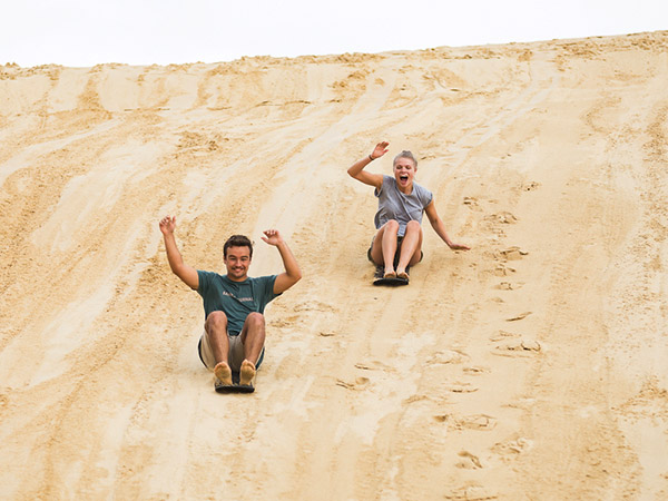 Sliding down the sand dunes, Tin City, Port Stephens, NSW Australia