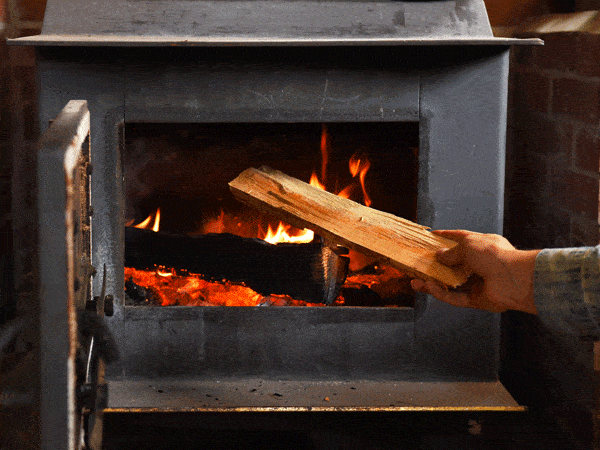 Man putting wood into fireplace
