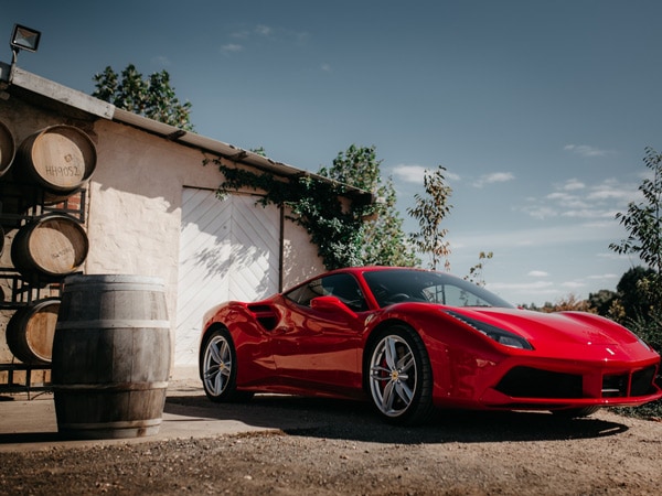 A red Ferrari is parked at a South Australian winery as part of the Prancing Horse Drive Experience (Image: Erik Rosenberg)