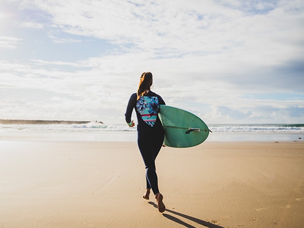 Woman with surf board, Turners Beach, Yamba, NSW, Australia