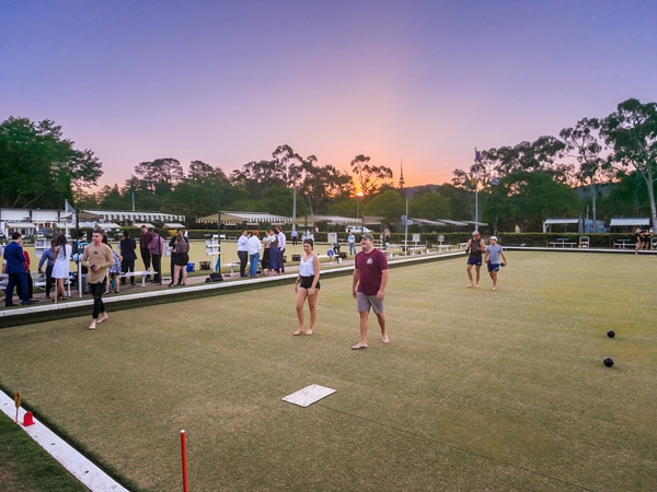A group of people play sunset barefoot bowls. (Image: The RUC)