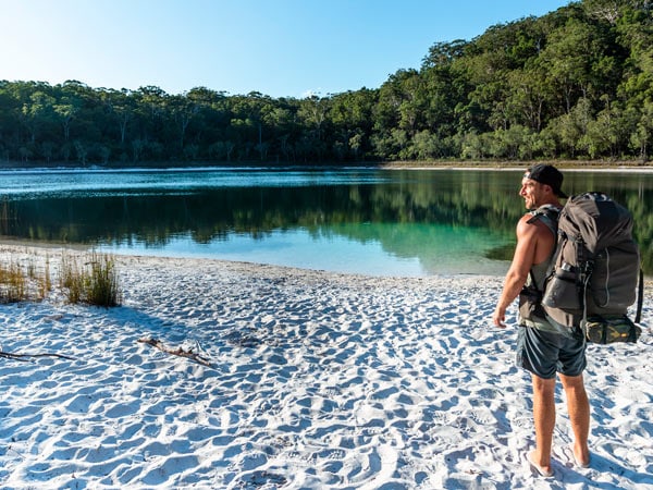 A barefoot traveller hiking at Basin Lake. (Image: Tourism and Events Queensland)