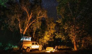 A 4WD is parked by a campfire under the stars at Lorella Springs Wildnerness on the Savannah Way, Northern Territory. (Image: Tourism NT/Sean Scott)