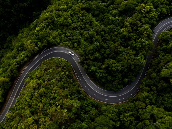 An aerial shot of a car driving along the Bloomfield Track in the Daintree (Image: Tourism and Events Queensland and Sean Scott)