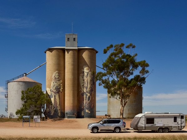 Kaff-eine's Rosebery silo on the left shows a young female farmer, and the silo on the right portrays a quiet moment between man and horse. (Image: Visit Victoria/Anne Morely)
