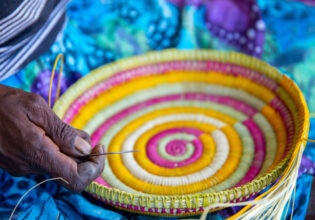 an Indigenous artist weaving a basket at the Injalak Arts and Crafts Centre