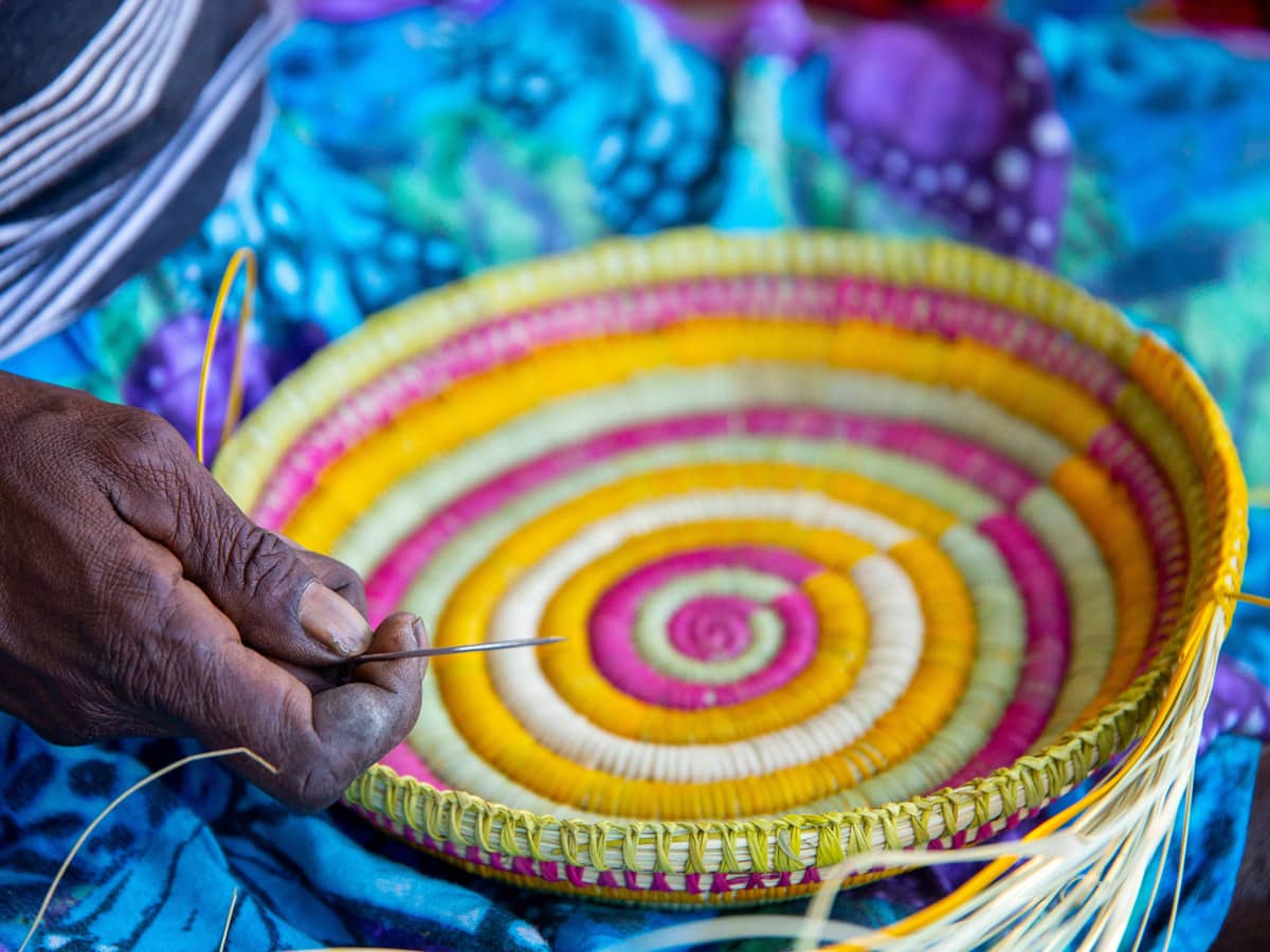 an Indigenous artist weaving a basket at the Injalak Arts and Crafts Centre