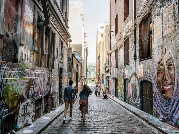 A couple walk down Hosier Lane in Melbourne. (Image: Visit Victoria/Ain Raadik)