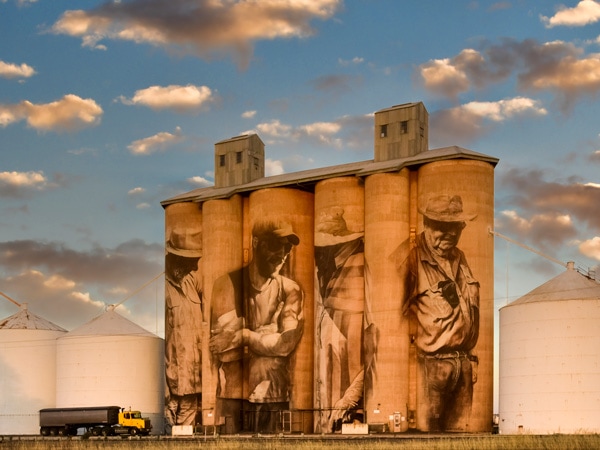 Guido van Helten's silo art in Brim depicts a multi-generational quartet of female and male farmers across four silos. (Image: Visit Victoria/Anne Morely)