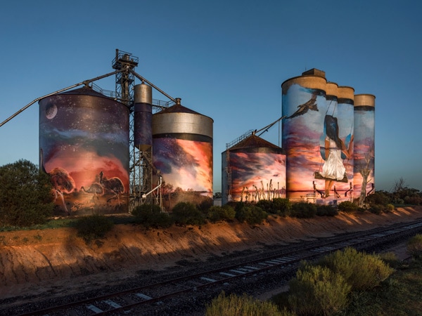 Joel Fergie and Travis Vinson painted the silo artwork at Sea Lake of a young girl, swinging from a Mallee Eucalyptus, looking over Lake Tyrrell and reflecting on her Indigenous heritage. (Image: Visit Victoria/Anne Morely)