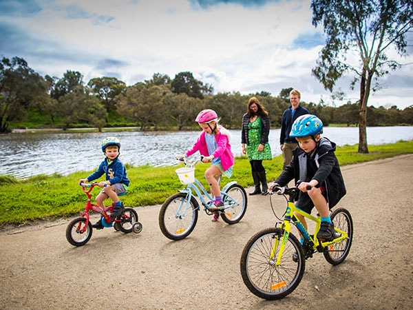 Children riding bikes at Barwon River and Park, Victoria, Australia