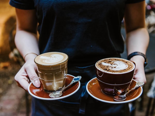 a person holding two cups of coffee at Alby & Esthers, Mudgee