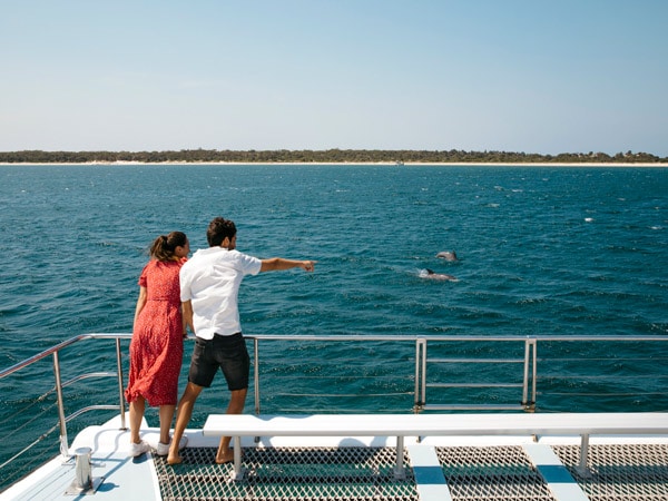 Couple enjoying a dolphin watching cruise with Moonshadow Cruises in Port Stephens. (Image: Destination NSW)