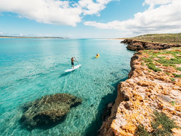People stand up paddle boarding on Dirk Hartog Island. (Image: Tourism Western Australia)