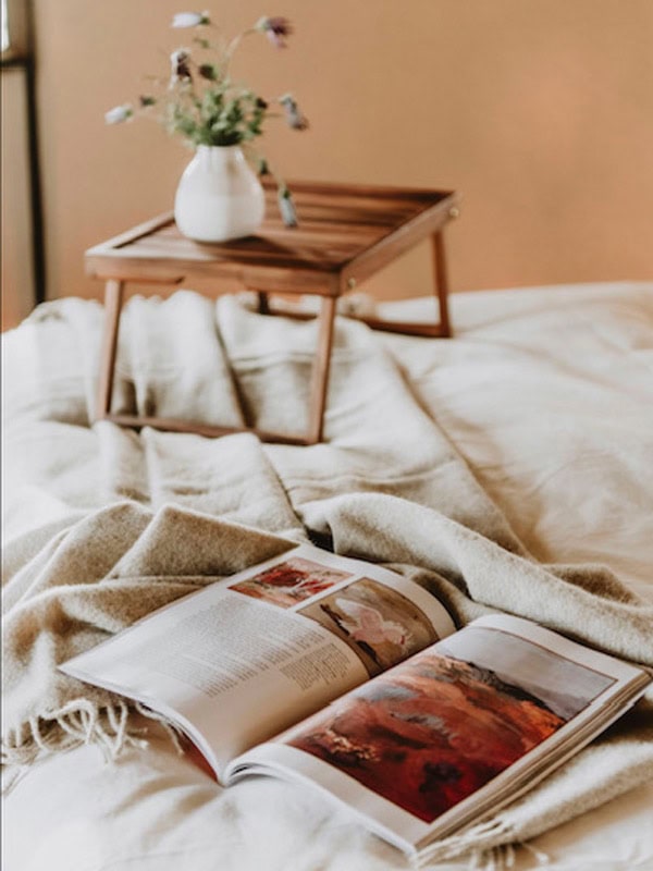 a book on the bed at Evamor Valley