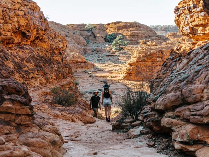 Man and woman trekking across Kings Canyon. (Image: Tourism NT and Jess Caldwell & Luke Riddle)