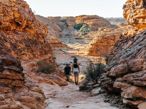 Pria dan wanita trekking melintasi Kings Canyon.  (Gambar: Tourism NT dan Jess Caldwell & Luke Riddle)