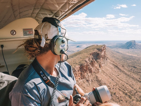 A visitor aboard a helicopter tour over Tjoritja / West MacDonnell National Park. (Image: Tourism NT and Salty Aura)
