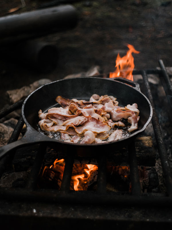 Cooking bacon over coals