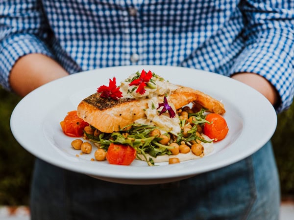 a person holding a plate of food at the Oriental Hotel