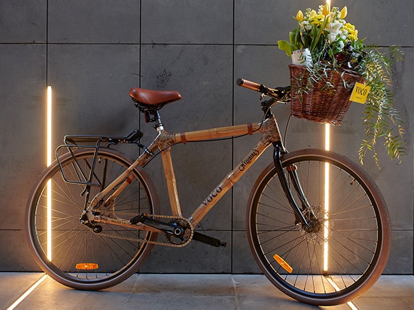 Ένα ποδήλατο με λουλούδια στο καλάθι ακουμπάει σε έναν γκρίζο τοίχο