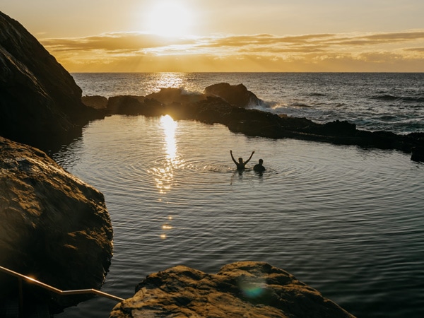 a couple enjoying a dip at Bermagui Blue Pool, Sapphire Coast, NSW