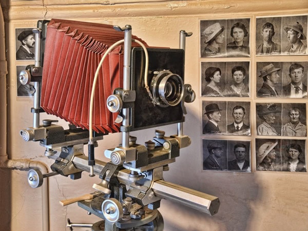 a vintage camera with black and white portraits on the wall at Hobart Convict Penitentiary