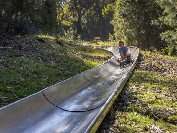 a child sliding down the Toboggan Slide at Magic Mountain Amusement Park in Merimbula