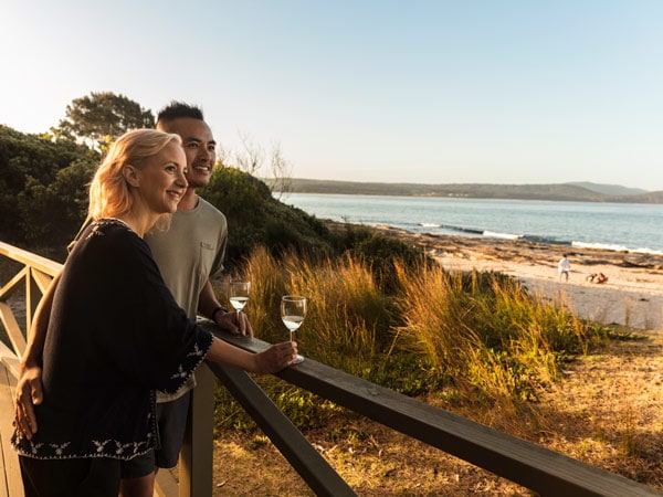 Ένα ζευγάρι πίνει κρασί δίπλα στην παραλία στο NRMA Murramarang Beachfront Holiday Resort στο Batemans Bay, NSW, Αυστραλία