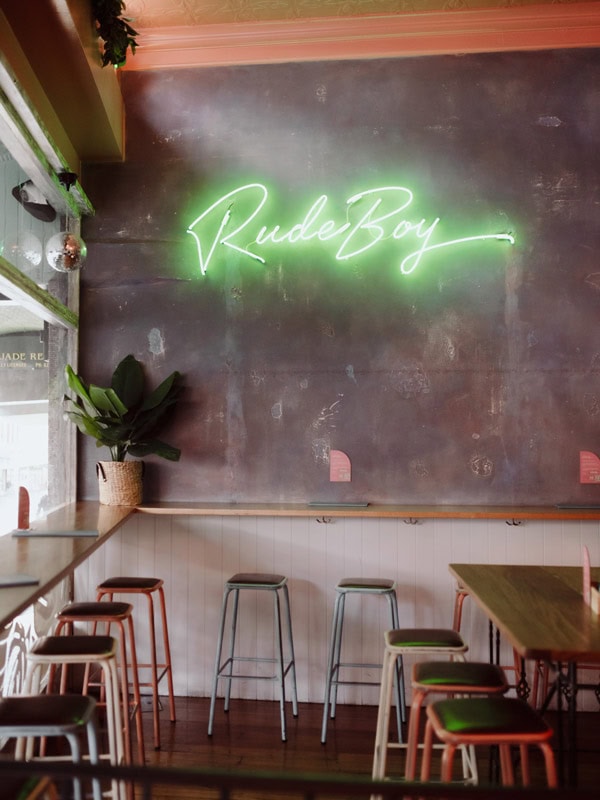 the bar interior of Rude Boy with a neon-lit signage on the wall