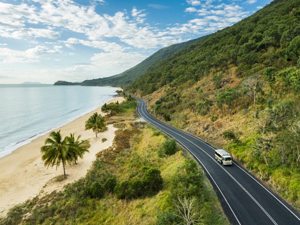 Tour bus driving along the Great Barrier Reef Drive. (Image: Tourism Tropical North Queensland)