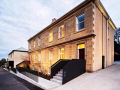 The house is made of stone and has a black railing.