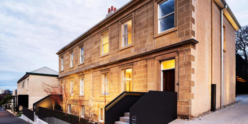 The house is made of stone and has a black railing.