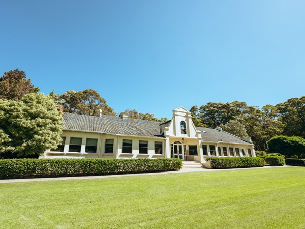 A white house with a grey rood on grass