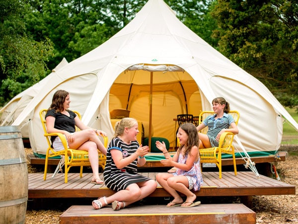 a family sitting outside a glamping tent at Park Lane Holiday Park, Yarra Valley