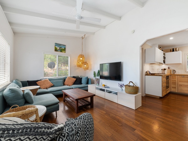 The indoors of a home with a couch, coffee table and tv and tv cabinet.