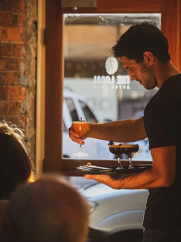 A waiter serving drinks at The Local After Dark in Glen Innes, NSW, Australia